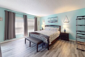 Cozy retreat with a large bed, wooden bench, and nightstand.