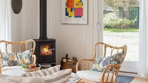 A cozy room with a wood-burning stove, wicker furniture, and a framed abstract painting. - "Josef" - 1.4km from the sea by Interhome (Nykøbing Sj)