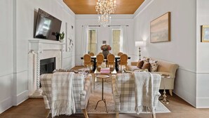 A dining area with a chandelier, a fireplace, and a sofa.
