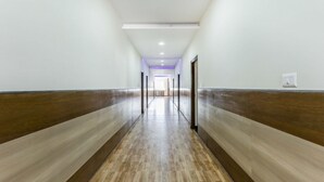 A long, narrow hallway with wooden paneling on the walls and a wooden floor.