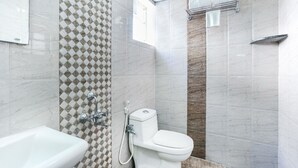 A bathroom with a white sink, a toilet, and a shower area.