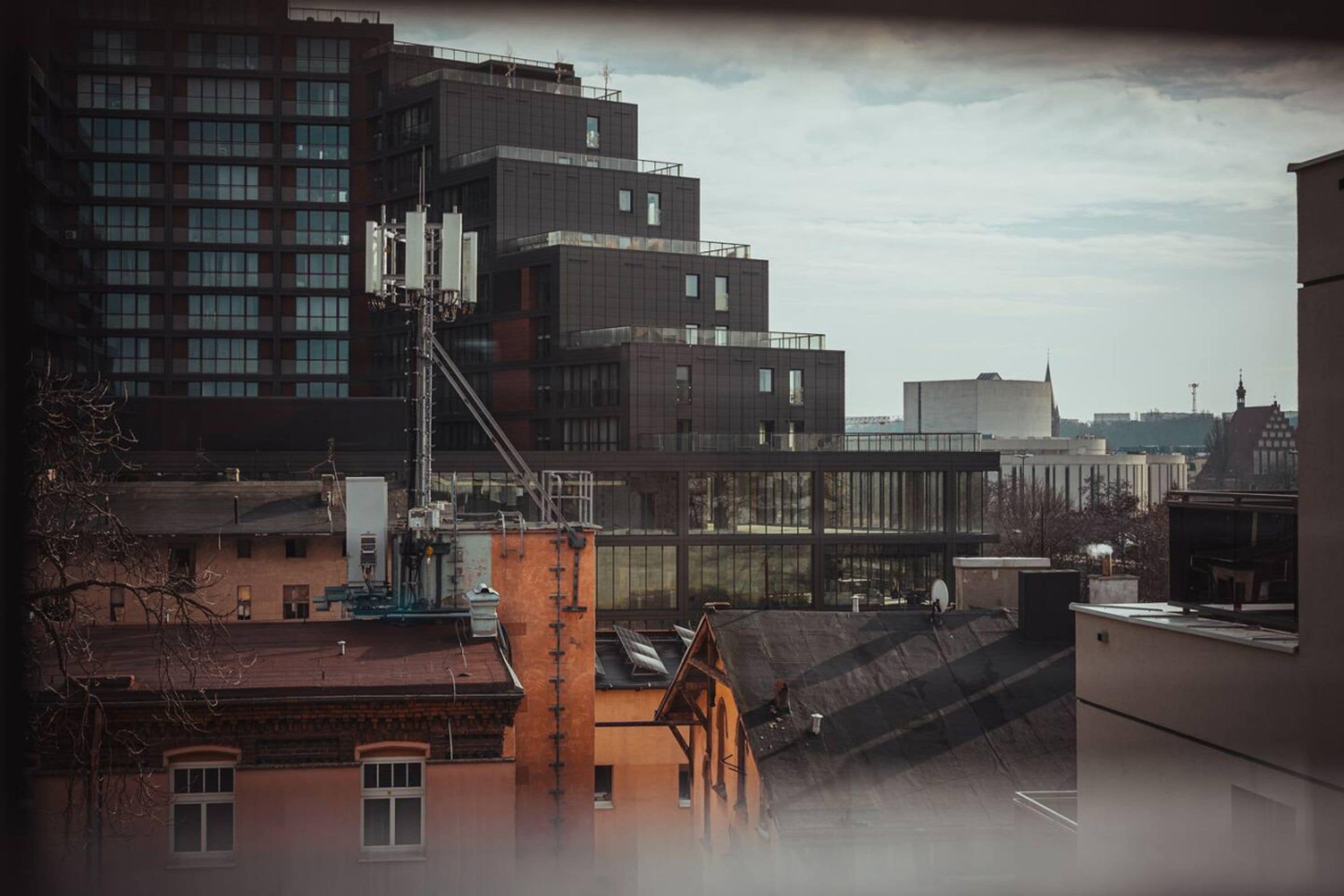 Een modern stadsgebouw met meerdere verdiepingen, grote ramen en een dakterras.