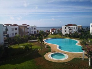 Un complexe hôtelier doté d’une grande piscine, de plusieurs bâtiments et offrant une vue sur l’océan.