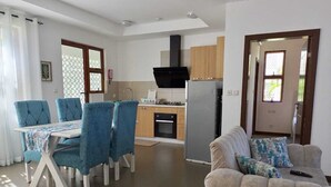 Une cuisine moderne avec un coin repas, comprenant une table avec des chaises, un canapé et un réfrigérateur.