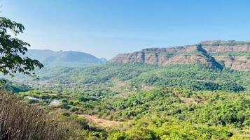 A mountainous landscape with dense greenery and a clear sky.