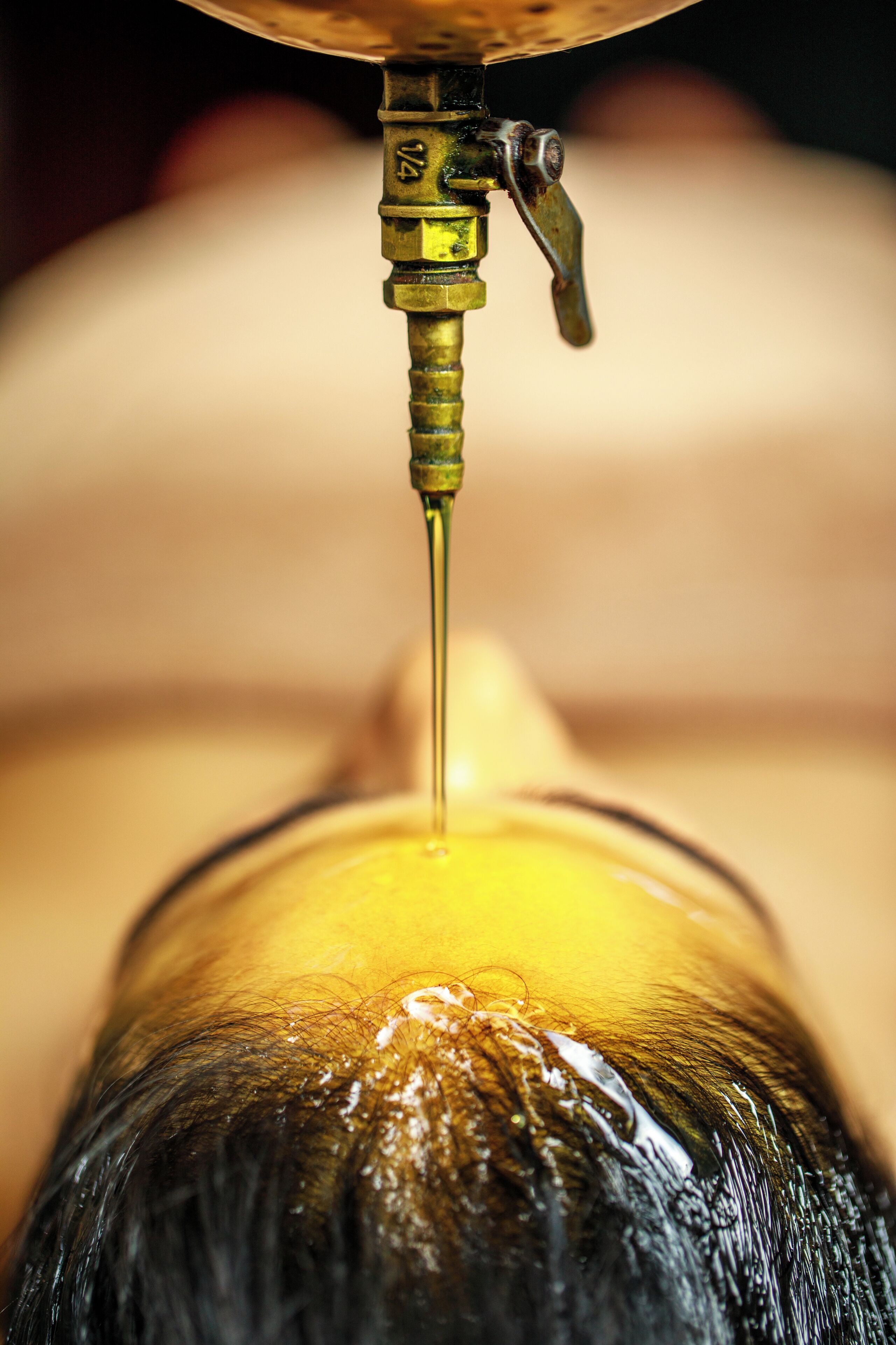A close-up of a hair washing process with a focus on the hair and water flow.