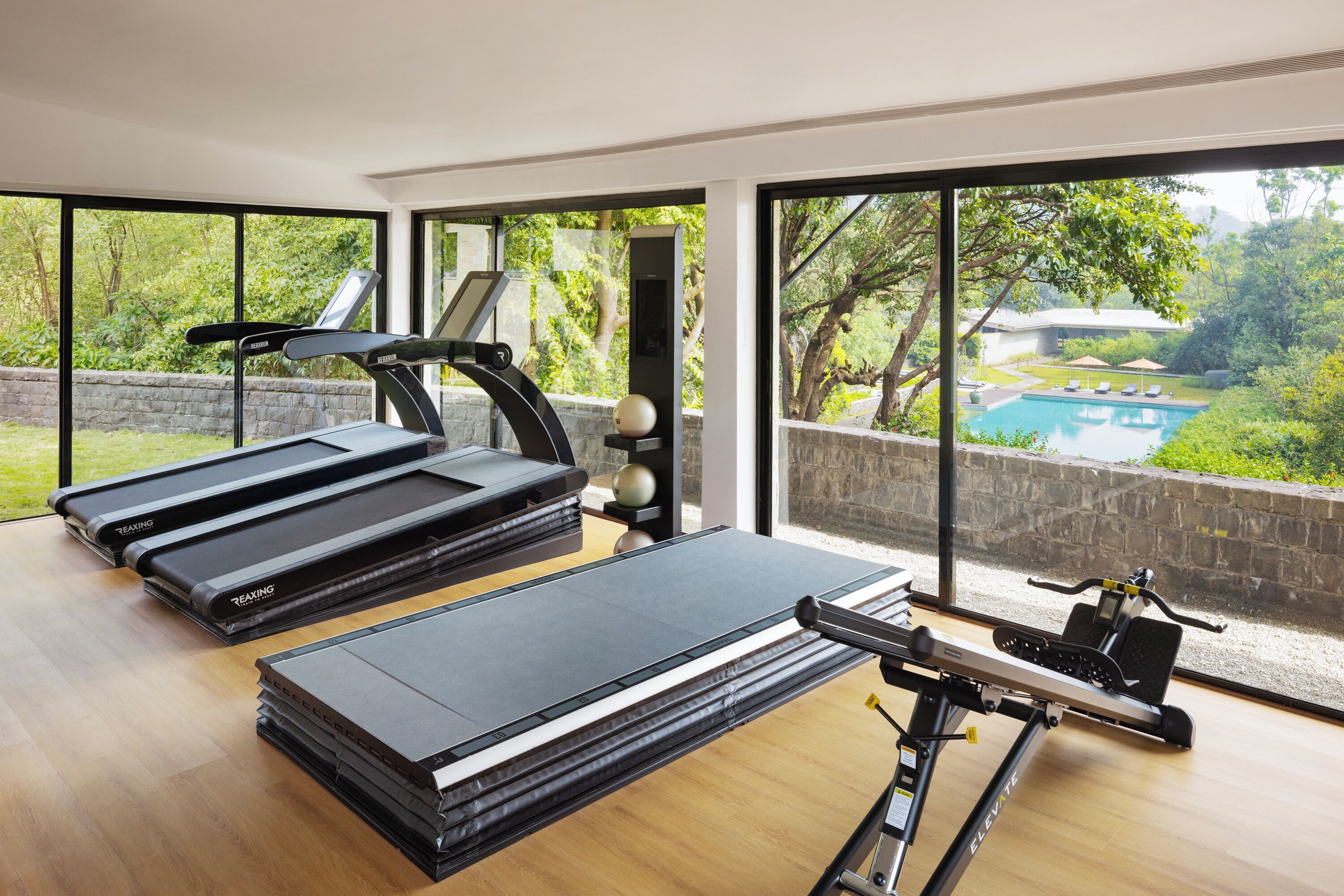 Une salle de sport à domicile équipée de tapis de course, d'un vélo d'appartement et d'une pile de poids.