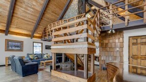 A spacious living area with a high wooden ceiling, a built-in wooden staircase, and a cozy seating area with a sofa and coffee table. - Moose Tracks Cabin! Secluded Mtn Retreat w/HotTub (Woodland Park)