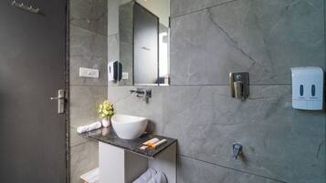 Un baño moderno con un espejo grande, un lavabo blanco y un perchero para toallas.