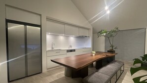 A modern kitchen with a large island, built-in appliances, and a bench. - BBQ (Mihama)
