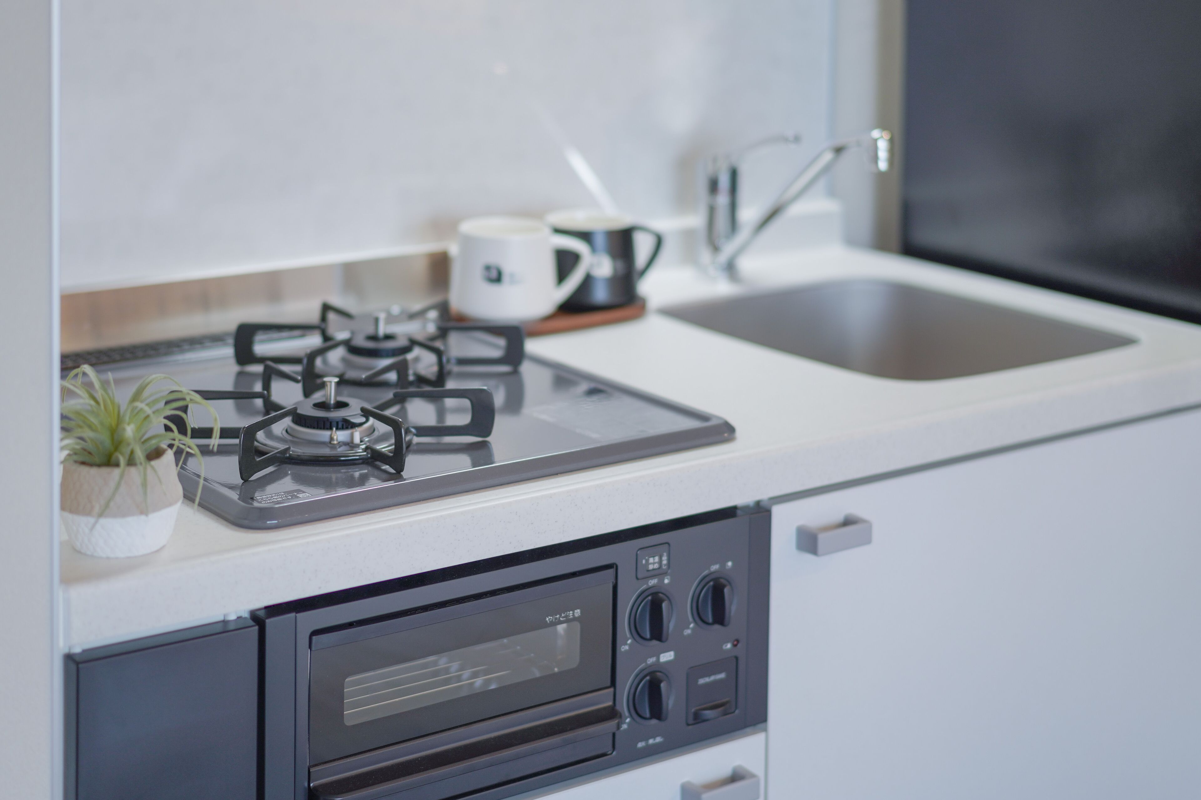 Una cocina con estufa a gas, microondas y pileta.