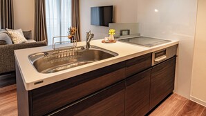 Een moderne keuken met een roestvrijstalen spoelbak, houten kastjes en een ingebouwde oven.