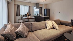 Een moderne woonkamer met een bank, een eettafel en een keukenhoek.