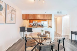 A modern kitchen with wooden cabinets, a microwave, and a refrigerator. - SMV* Bay* Front Oasis Brickell (Miami)