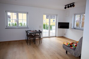 Relax in this stylish living space with a dining area, TV, and comfortable sofa.