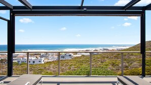 Ein Balkon mit Blick auf das Meer und Küstengebäude.