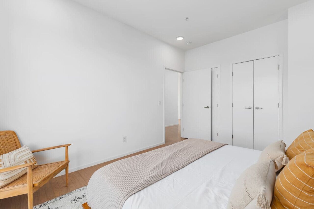 Une chambre à coucher avec un lit, une chaise et deux armoires.
