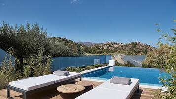 Relax by the serene pool surrounded by a stunning view of the surrounding landscape and distant coastline.