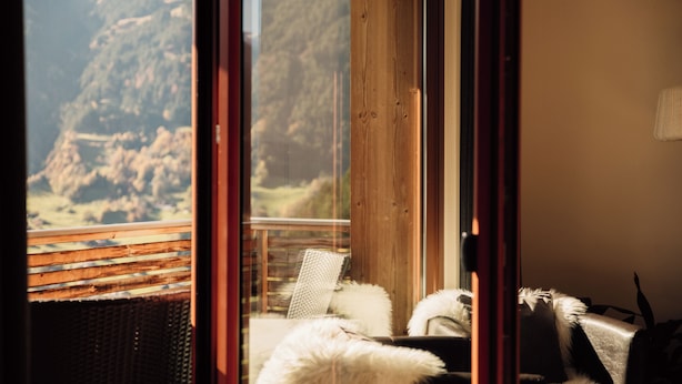 Habitación con vista a un paisaje montañoso a través de un ventanal.