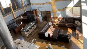 Un amplio espacio habitable con un sofá modular grande, una cocina con barra y un comedor.