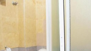Une salle de bain comprenant des toilettes, un lavabo et un espace douche.