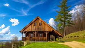 Eine Holzhütte mit Satteldach, einer Veranda und Blick auf die umliegende Landschaft.