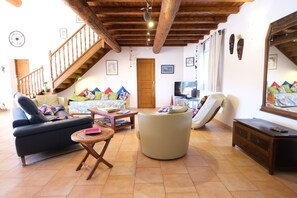 A living room with a sofa, armchair, and a small table. There is a wooden staircase and a door in the background. - Vacation rental house with pool AUREILLE LS1-439 (Aureille)