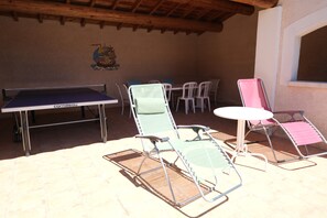 An outdoor seating area with a ping pong table, lounge chairs, and a small table. - Vacation rental house with pool AUREILLE LS1-439 (Aureille)