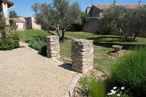 A courtyard with stone pillars, olive trees, and a gravel path leading to a building. - Vacation rental house with pool AUREILLE LS1-439 (Aureille)