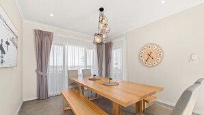 Un coin repas avec une table en bois, des bancs et une horloge murale.