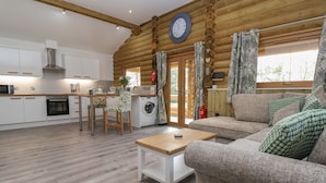 Interior acogedor de una cabaña de troncos con cocina, comedor y sala de estar.