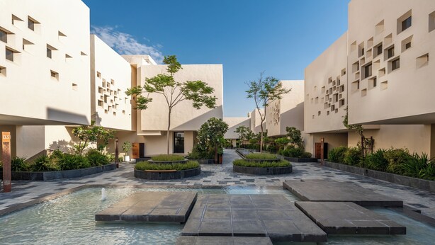 A modern courtyard with water features, geometric landscaping, and minimalist architecture.