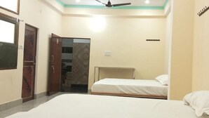 Quarto com duas camas, um guarda-roupa e um ventilador de teto.