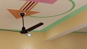 Quarto com cama, ventilador de teto e uma pequena mesa.