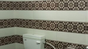Casa de banho com sanita, bidé e lavatório fixo à parede.