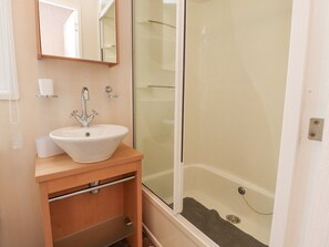 A bathroom with a sink, mirror, and shower. - Larenzo (Preston)