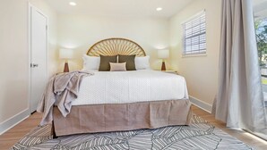 A bedroom with a bed, bedside lamps, a ceiling fan, a window with blinds, and a door. - Walk Downtown, Free Parking, By Conch House, Games (St. Augustine)