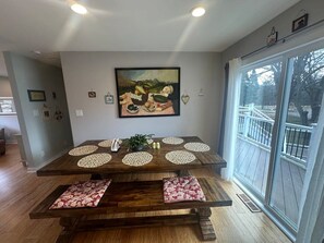 Una mesa de comedor con individuales y un cuadro colgado encima.
