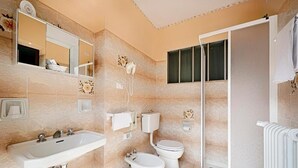 A bathroom with a sink, bidet, toilet, and shower. - Albergo Mancuso del Voison (Aosta)