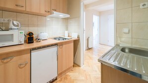 A modern kitchen with wooden cabinets, a built-in microwave, a coffee maker, and a dishwasher.