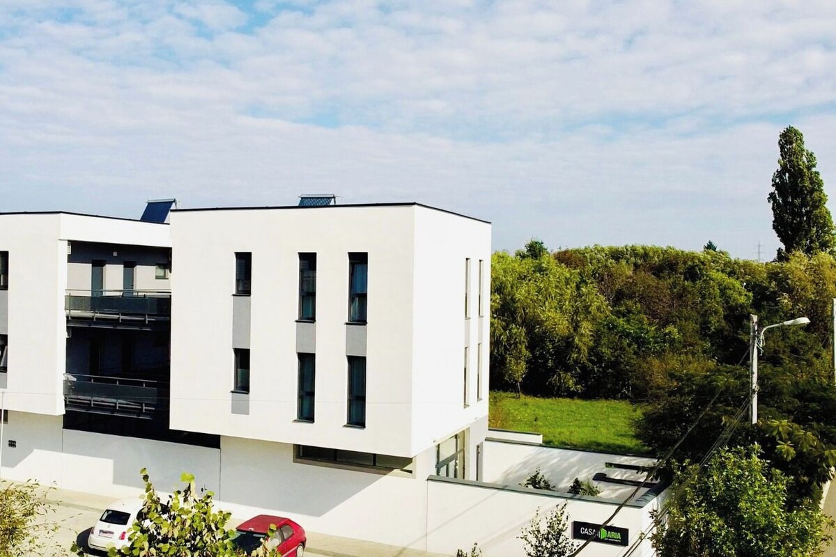 Un bâtiment moderne à deux étages, doté d’un toit plat, de grandes fenêtres et d’une façade lisse.