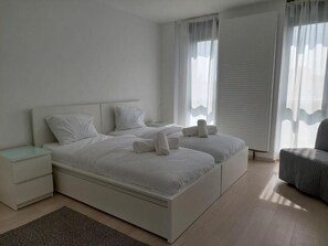 A modern bedroom with a large bed, two bedside tables, and a chair.