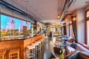 A bar area with stools, a counter with a menu, and seating with tables and sofas. - Private 4-bed Room Ensuite (Dresden)
