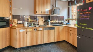 Une cuisine moderne avec des meubles en bois, un lave-vaisselle encastré et un évier en acier inoxydable.