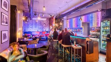 A bar area with seating, a bar counter, and a refrigerator stocked with beverages.