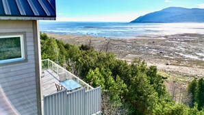 Ein Haus mit einem Balkon mit Blick auf Strand und Meer.