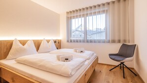 A hotel room with a bed, a chair, and a window with curtains. - HUUS123, Apartment 4 (Au)