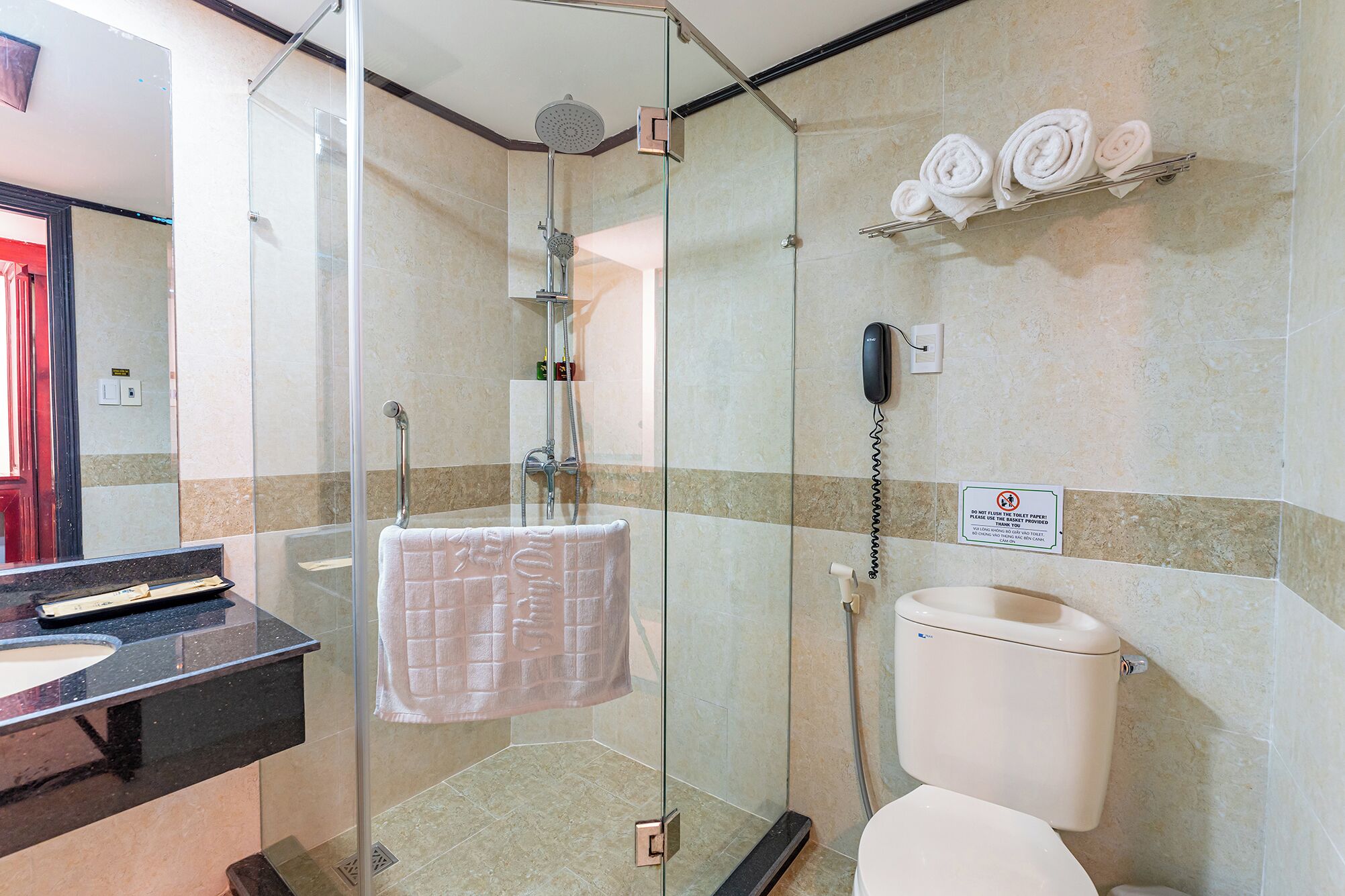 Un bagno con doccia vetrata, un water e un lavandino.
