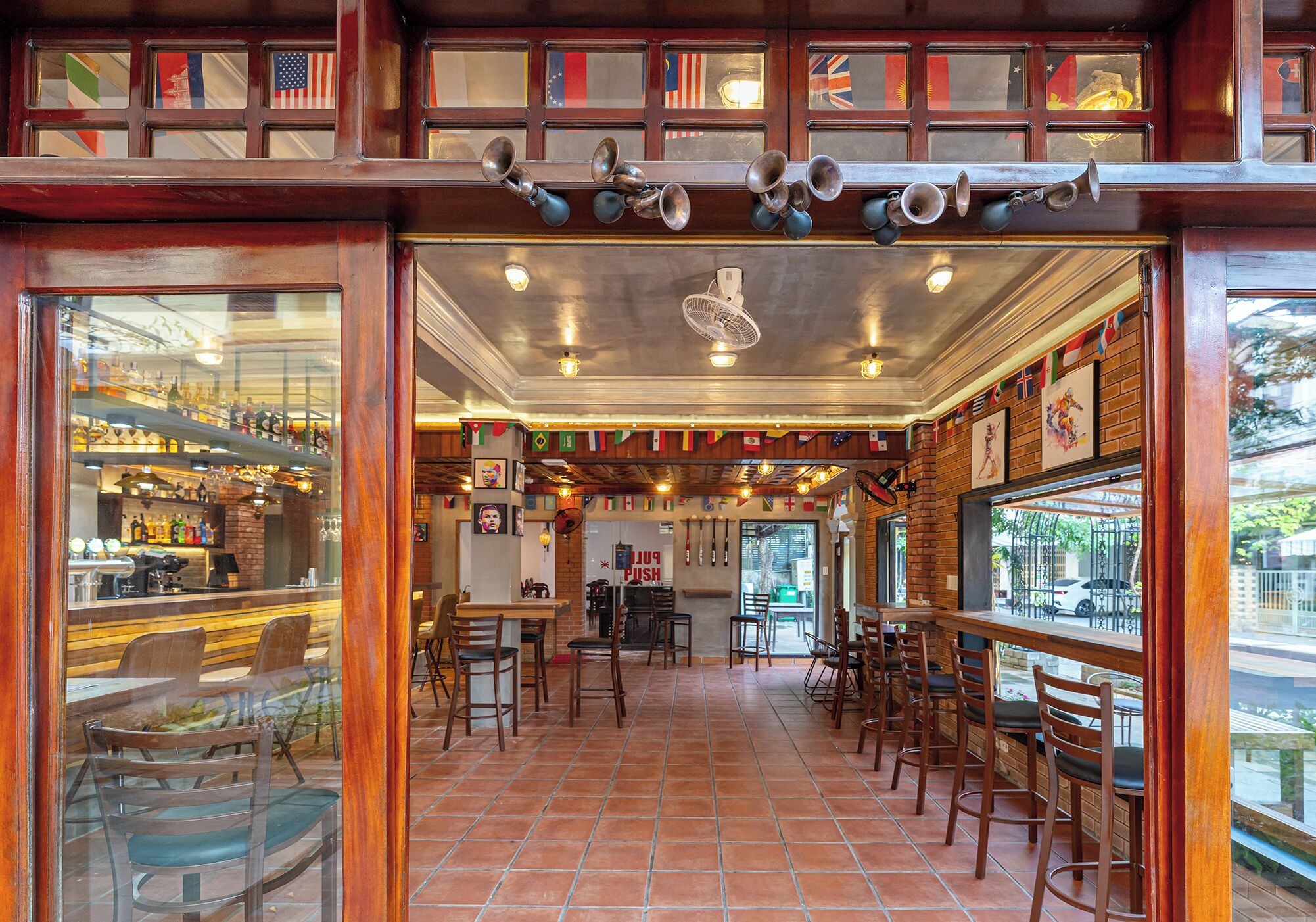 A restaurant with a bar area, multiple seating options, and a view of the street.
