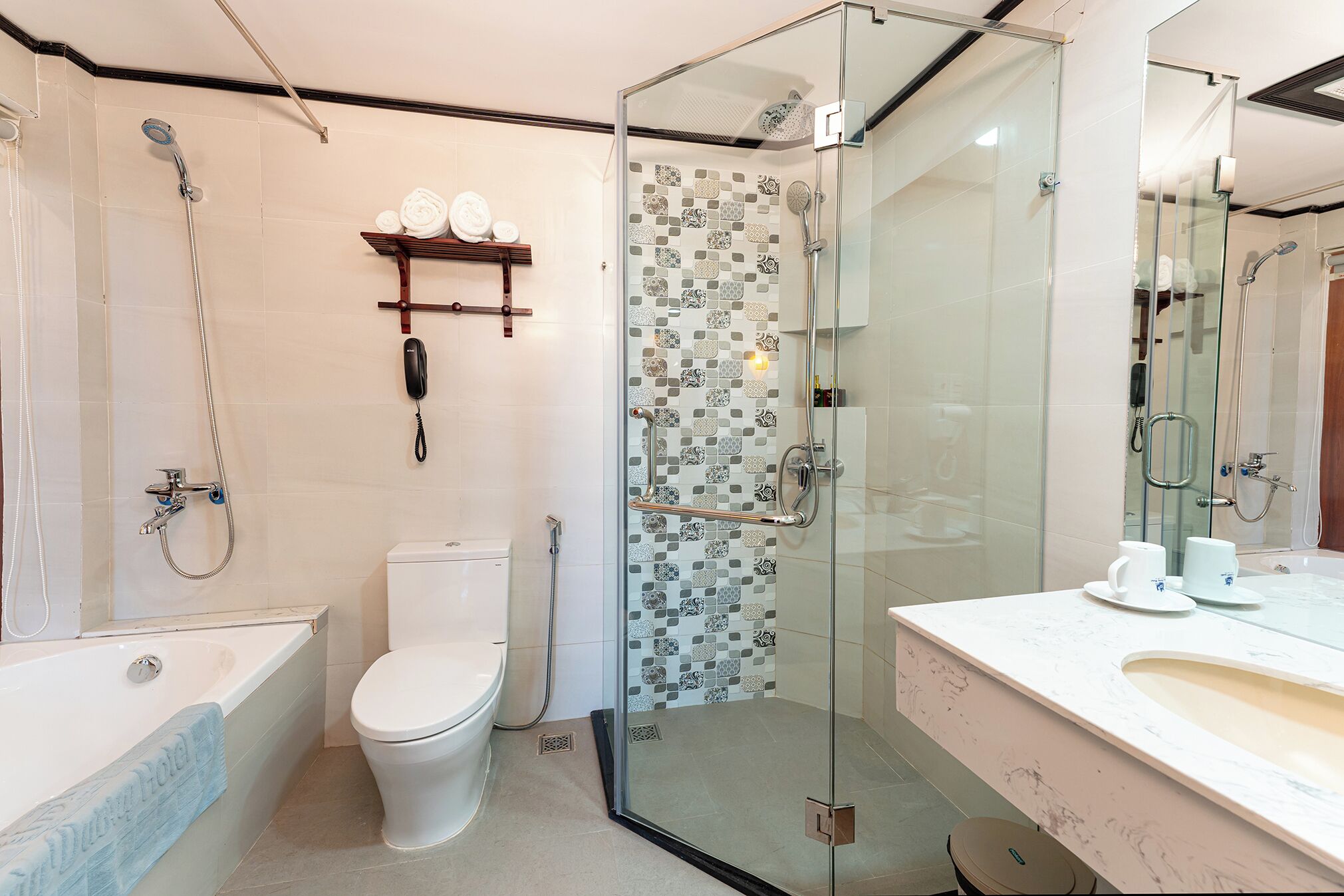 A modern bathroom with a glass-enclosed shower, a toilet, a bathtub, and a vanity with a mirror.